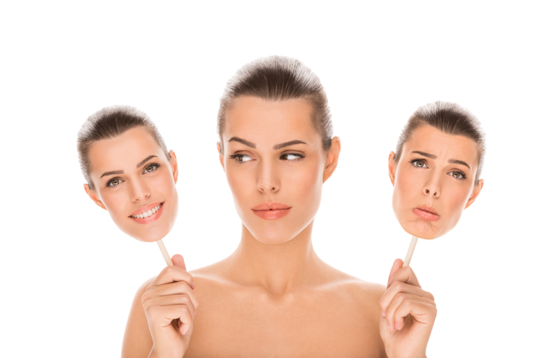 A woman holding a placard with happy and sad faces, symbolizing emotional transformation, while practicing Emotional EFT Tapping at Therapeutic Touch Clinic to overcome stress and achieve emotional balance.
